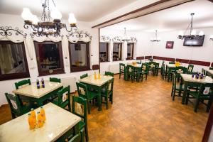 un restaurante vacío con mesas verdes y sillas en Casa Dracula by Pro Lex en Bran