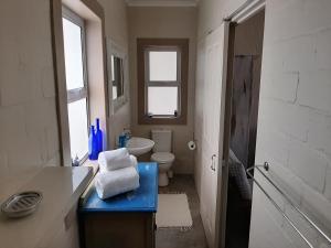 baño con lavabo y aseo y ventana en WestBed en Langebaan
