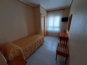 a bedroom with a bed and a chair at Hotel Cano in Torrevieja