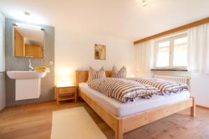 a bedroom with a bed with a sink and a window at Landhaus Tröster in Ofterschwang