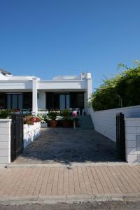 una casa blanca con una puerta delante de ella en Panorama Leukos, en Castrignano del Capo