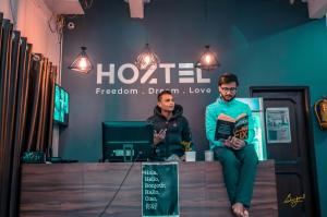 two men sitting on a counter in a room at Hoztel Jaipur in Jaipur