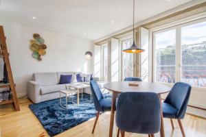 een woonkamer met een tafel en stoelen en een bank bij São Bento Hill View in Porto