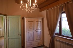 a room with a chandelier and a cabinet and a window at Villa Manu in Lapedona