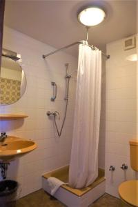 y baño con ducha y cortina de ducha. en Hotel Simonis Koblenz, en Coblenza