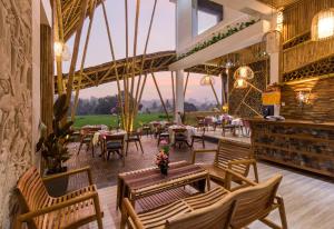 a restaurant with tables and chairs and a large window at Wadari Retreat Villa Ubud in Ubud