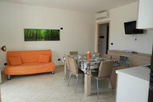 - une salle à manger avec une table et un canapé orange dans l'établissement Appartamento Tresor 1, à Gallipoli