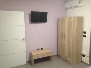 een kamer met een tafel en een tv aan de muur bij B&B Italia in Carmiano
