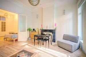een woonkamer met een tafel en een stoel bij The Greenplace Apartments in the Heart of Antwerp in Antwerpen