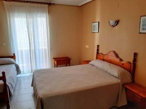 
a bedroom with a bed and a desk at Hotel Cano in Torrevieja
