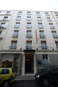 un edificio blanco con coches estacionados frente a él en HOTEL DU MONT LOUIS en París