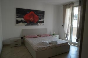- une chambre avec un lit orné d'une fleur rouge sur le mur dans l'établissement Appartamento Tresor 1, à Gallipoli