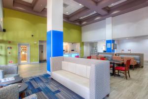 a waiting room with a couch and tables and chairs at Holiday Inn Express Hotel & Suites Tempe, an IHG Hotel in Tempe