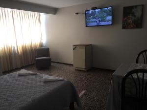 Habitación con 2 camas y TV en la pared. en Hotel Plazza en Chiclayo
