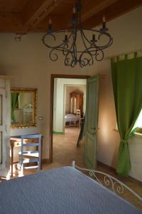 - une chambre avec un lit et un lustre dans l'établissement Villa Manu, à Lapedona