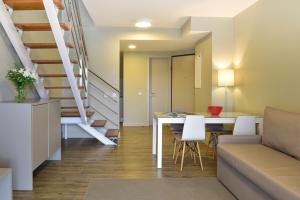 a living room with a table and a staircase at Aqualuz Lagos by The Editory in Lagos