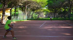 zwei Personen, die Tennis auf einem Tennisplatz spielen in der Unterkunft Horse Country Resort Congress & Spa in Arborea 