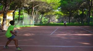 2 persone che giocano a tennis su un campo da tennis di Horse Country Resort Congress & Spa ad Arborea