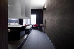 a bedroom with a bed and a sink and a bathroom at Carbon Hotel in Genk