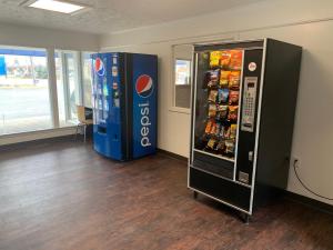 uma máquina de refrigerantes e uma máquina de venda automática de refrigerantes numa sala em Motel 6-North Olmsted, OH - Cleveland em North Olmsted