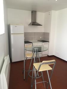 una cucina con tavolo, sedie e frigorifero di Chez Mimi a Châtillon-sur-Seine