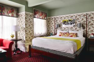 a bedroom with a large bed and a red chair at White Swan Inn in San Francisco