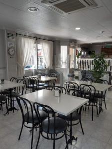 a restaurant with tables and chairs in a room at Hotel Cano in Torrevieja