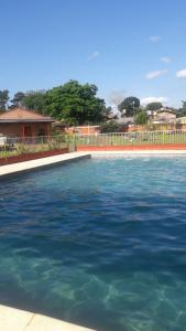 a swimming pool with blue water in front of a house at Mi Buen Refugio in Puerto Iguazú