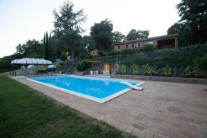 a swimming pool in a yard next to a house at Villa-Alta in Imola