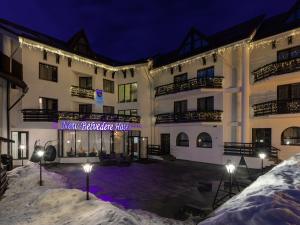 a hotel in the snow at night at Hotel Miruna - New Belvedere in Poiana Brasov