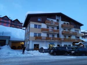 パッソ・デル・トナーレにあるAppartamento DIAMANTEの雪の建物の前に立つ者