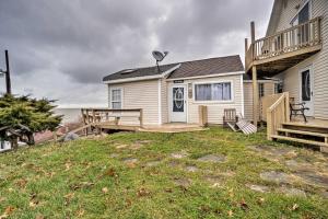 a house with a porch and a deck next to the ocean at Lakefront Geneva Vacation Rental - Walk to Strip! in Geneva-on-the-Lake