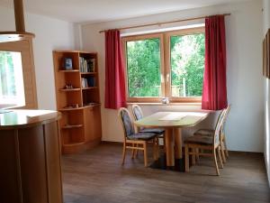 ein Esszimmer mit einem Tisch, Stühlen und einem Fenster in der Unterkunft Brunnerhof in Naturns