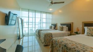 蒙特里亚Hotel Santorini Loft的一间有三张床和一台平板电视的酒店房间