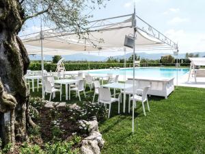 un patio con mesas y sillas junto a una piscina en Tenute del Gheppio, en Dugenta