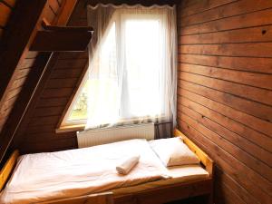 Cama pequeña en habitación con ventana en Domki Brda, en Karpacz