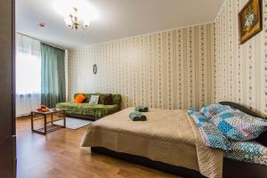 a bedroom with a bed and a green chair at Apartments near metro Osokorki, Borispol Airport, Adonis Clinic in Kyiv