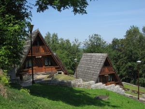 a couple of log homes with trees in the background at Domki Brda in Karpacz