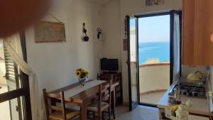 una cucina con tavolo e vista sull'oceano di Bellavista a Marina di Camerota