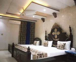 a bedroom with a large bed in a room at Grand Palace Hotel in Lahore