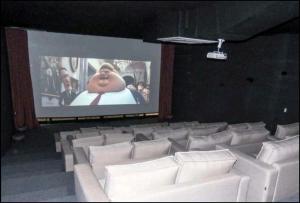 a large screen in a theater with white chairs at Maravilhoso Apartamento Reserva DNA Ubatuba in Ubatuba +35 photos