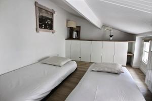 two beds in a room with white walls at 103275 - Appartement 4 personnes Temple - République in Paris