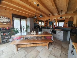 a large kitchen with a large wooden table in it at Chalet du champs des semeaux in Wisches