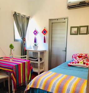 1 dormitorio con cama, mesa y ventana en Cozy Little Apartment en Sayulita