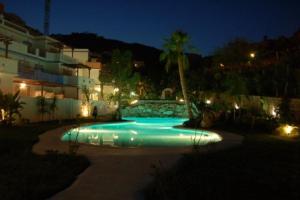 a swimming pool at night in front of a building at Marino apartment in Almuñécar