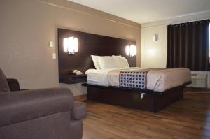 a hotel room with a bed and a couch at Hill Country Inn in Marble Falls +7 photos