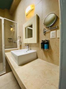 a bathroom with a white sink and a mirror at Hotel Casona Oaxaca in Oaxaca City