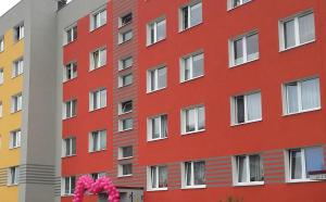 ein rotes Gebäude mit weißen Fenstern in der Unterkunft Apartament M-3 in Częstochowa
