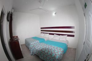 mały pokój z 2 łóżkami w pokoju w obiekcie Caribbean Hotel Santo Domingo w mieście Santo Domingo