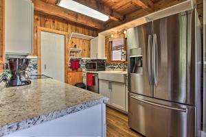 a kitchen with a stainless steel refrigerator and wooden walls at Rustic Cabin with Screened Deck 8 Mi to Dollywood in Sevierville